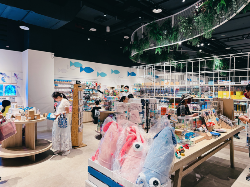 2026台中海洋館必看9大展區攻略!便宜門票/預約方式/海線一日遊路線推薦-TaichungAquarium 54 台中海洋館紀念品區,展示桌與貨架陳列魚形玩偶及海洋主題商品